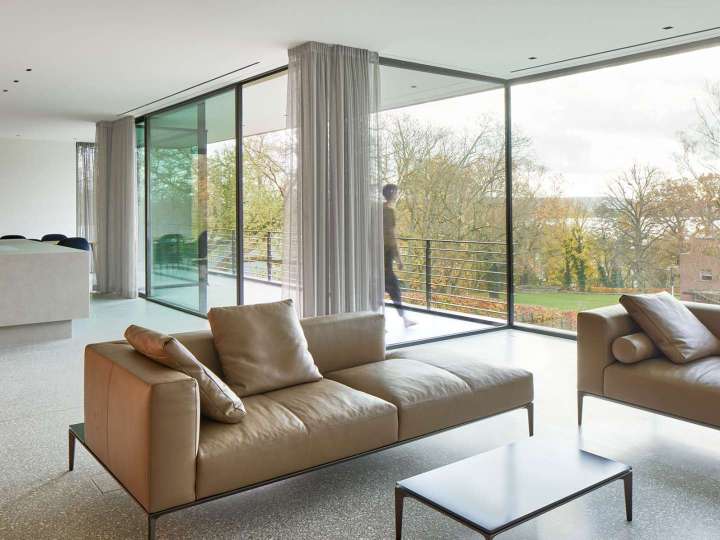 Blick in ein Wohnzimmer mit verglaster Fassade