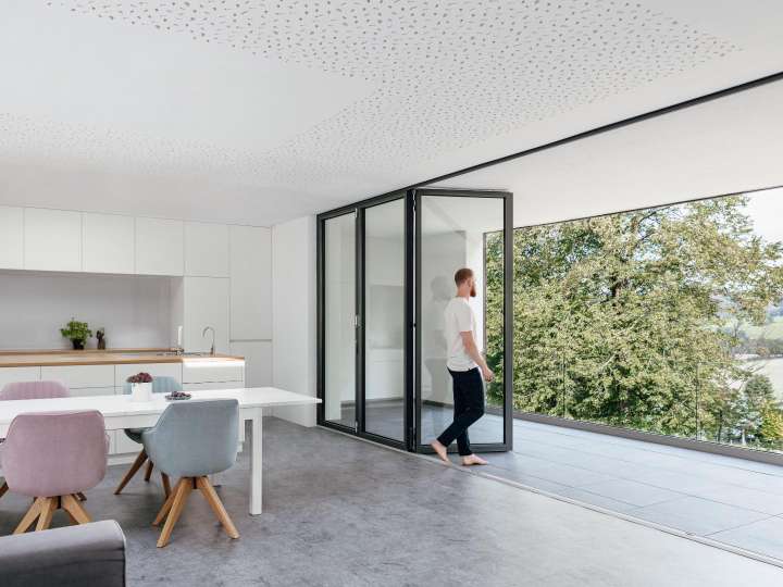 Mann steht an einer Solarlux Glas-Faltwand